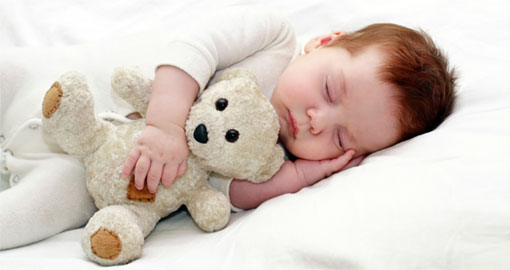 תינוק ישן ומחבק בובה